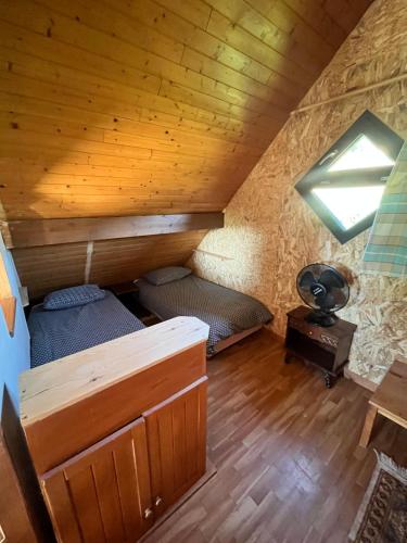 Cette chambre mansardée comprend 2 lits et une fenêtre. dans l'établissement l'oreille du pelerin - colibri, à Saint-Jacques-des-Arrêts