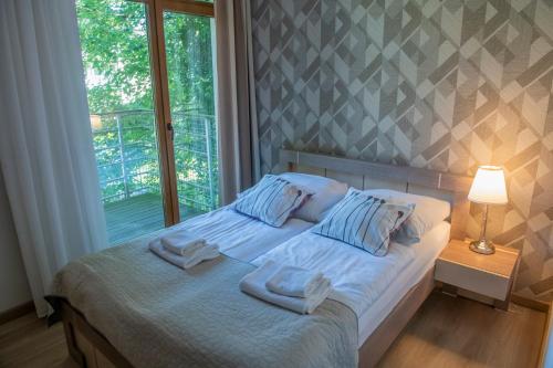 a bedroom with a bed with towels on it at Rezydencja Familia in Świnoujście
