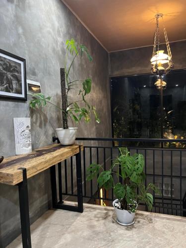 a balcony with a wooden table and two potted plants at D'Rus Hill munduk in Singaraja