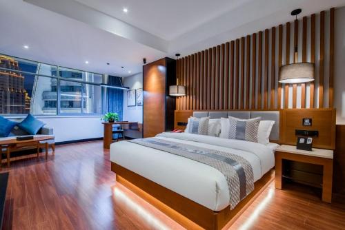 a bedroom with a large bed and a living room at Xishuangbanna Jinghong Wanji Lijing Hotel in Jinghong