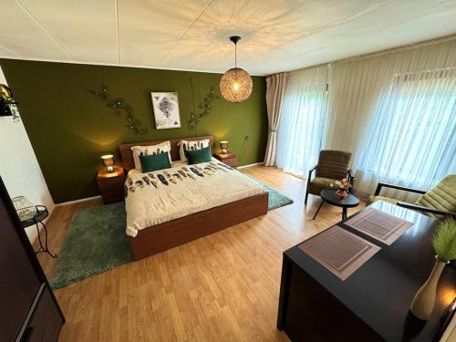 a bedroom with a bed and a green wall at Villa Grenszicht in Nispen