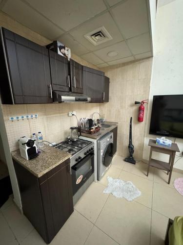 una cucina con fornelli e lavatrice di Private Condo ad Ajman
