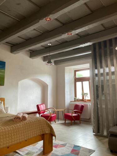 a bedroom with a bed and chairs and a table at Historic Center Apartment in Spišské Podhradie