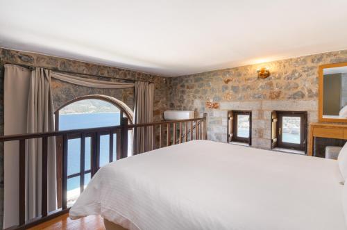 a bedroom with a large bed and a balcony at Limeni Village in Limeni