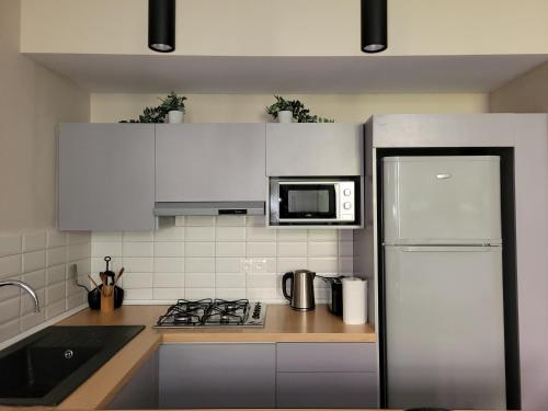 a kitchen with white cabinets and a white refrigerator at L'écrin parfait pour votre évasion à Rabat in Rabat