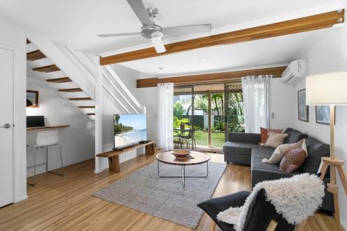 a living room with a couch and a table at Nautilus Noosa Resort in Noosaville