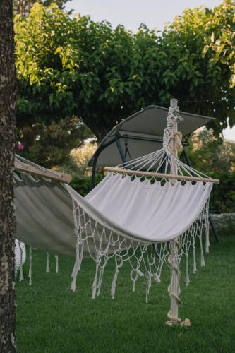 a hammock in the grass next to a gazebo at Evoikos beach & resort in Livanátai