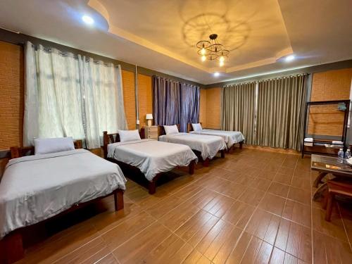 a row of beds in a room with a room with at MRK Resort & Massage in Lop Buri