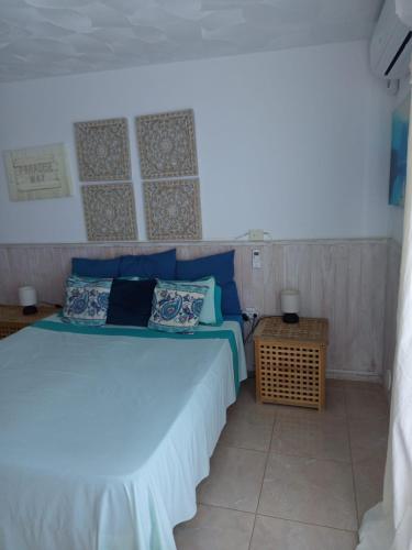 ein Schlafzimmer mit einem Bett mit blauen Kissen in der Unterkunft Aquarius Loft in Callao Salvaje