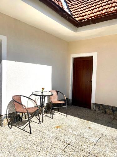 a patio with a table and chairs and a door at U Parku, Nová Ves in Křemže