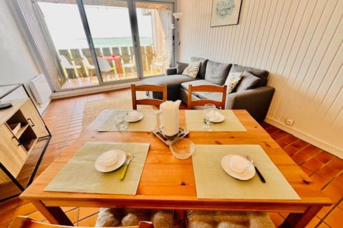 un salon avec une table et un canapé dans l'établissement Bright apartment with balcony near the sea, à La Rochelle
