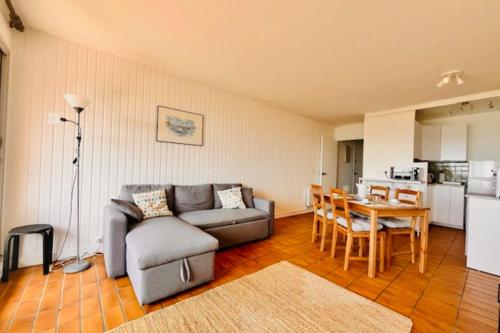 un salon avec un canapé et une table dans l'établissement Bright apartment with balcony near the sea, à La Rochelle