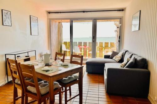 un salon avec une table et un canapé dans l'établissement Bright apartment with balcony near the sea, à La Rochelle