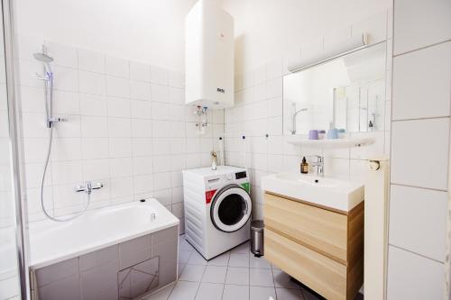 a bathroom with a washing machine and a washer and dryer at GH Luxury Apartments Graz, Glockenspielplatz in Graz