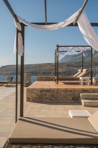a tent on a deck with a view of the mountains at Limeni Village in Limeni