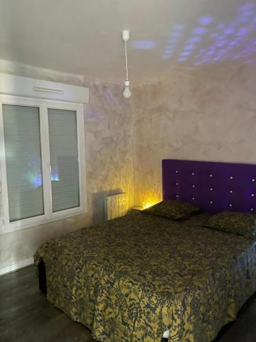 a bedroom with a bed with a purple headboard and a window at Maison propre et calme à 5 min du Futuroscope in Chasseneuil-du-Poitou