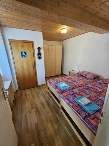 a bedroom with a bed and a wooden floor at Casa Galett in Novaggio