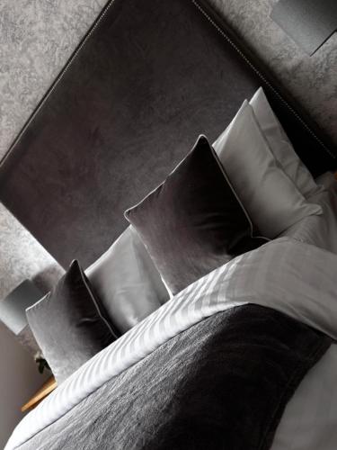a bed with black pillows on top of it at Alex Court in Leixlip