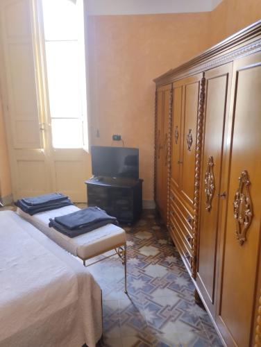 a bedroom with two beds and a dresser and a tv at Palazzo Spiga in Quartu Sant'Elena