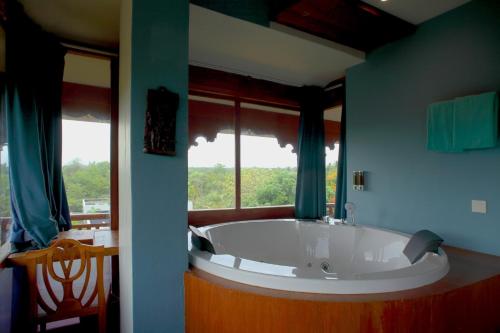 a large bath tub in a room with a window at The Dune Eco Village and Spa - Pondicherry in Puducherry