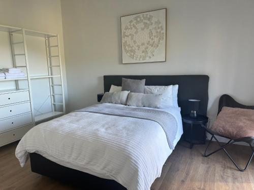 a bedroom with a large bed and a chair at Valley Views Luxury Country Retreat in Clarendon