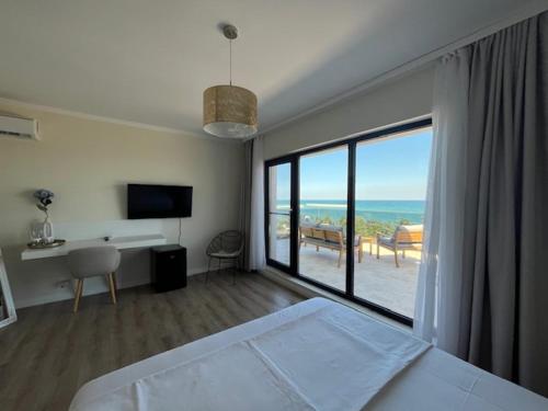 a bedroom with a bed and a view of the ocean at Vela Olimp in Olimp