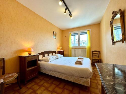 a bedroom with a bed and a table in it at L'Escapade du Midi in La Celle-sous-Gouzon