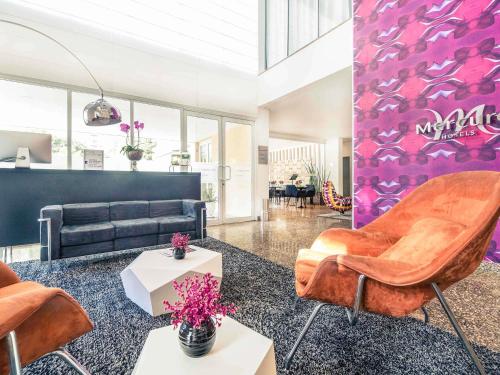 a living room with a couch and chairs in it at Mercure Sao Paulo Vila Olimpia in São Paulo