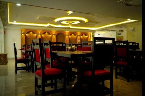 a restaurant with red chairs and a table with a sink at Hotel Jaisal Inn - Pure Veg in Jaisalmer