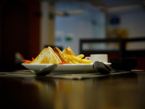 a plate of food with a sandwich and french fries at Hotel Jaisal Inn - Pure Veg in Jaisalmer