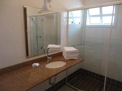 a bathroom with a sink and a mirror at Hotel Casarão Pitangueiras in Guarujá