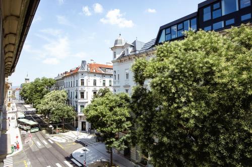 vistas a una calle de la ciudad con árboles y edificios en GH Luxury Apartments Graz, Gösser Haus, en Graz
