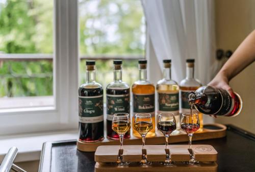 a person pouring wine into three wine glasses at Dwór Kombornia - Folwark in Kombornia