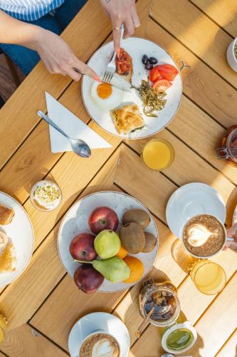 a wooden table with plates of breakfast food on it at Limeni Village in Limeni