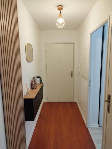 a hallway with a door and a table and a mirror at Beautiful 2-room apartment - Meaux - near Disneyland in Meaux