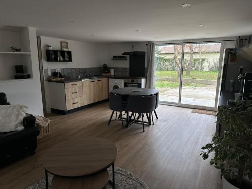 a living room with a table and chairs and a kitchen at Maison Familiale Gers 12 pers in Fleurance