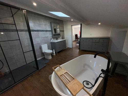 a large bathroom with a tub and a shower at Gîte familial Gers 12 pers in Fleurance