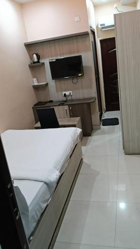 a small room with a bed and a television at Hotel JD Inn 