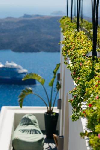 a balcony with potted plants and a view of the ocean at Kastro Suites in Fira