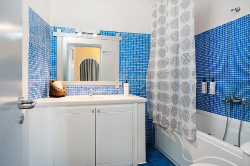 a bathroom with a white sink and a mirror at Kastro Suites in Fira