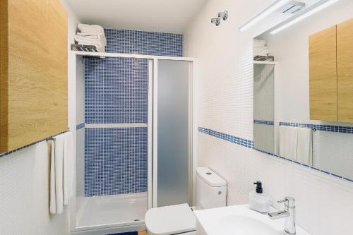 een badkamer met een douche, een toilet en een wastafel bij Apartamento Ría Punta Umbría in Punta Umbría