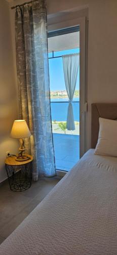 een slaapkamer met een bed en een raam met uitzicht bij APARTMAN SUNSIDE2 NIN in Nin