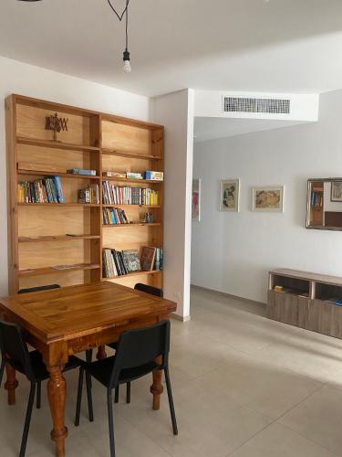 a dining room with a wooden table and chairs at MAISON ANZIO E ROSA in Ravenna