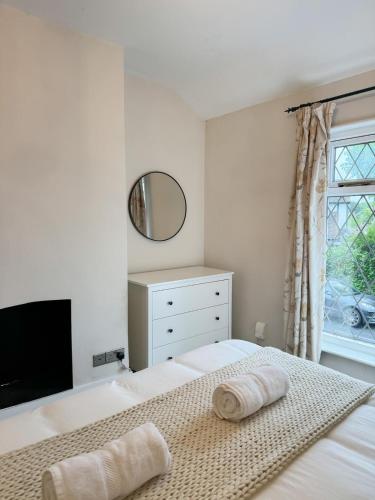 ein weißes Schlafzimmer mit einem Bett und einem Spiegel in der Unterkunft Rickmansworth Lodge in Rickmansworth