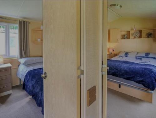 a bedroom with two beds and a mirror at Caravan 2 - Blackmoor farm near tenby in Ludchurch