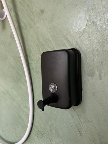 a black switch with a cord hanging on a wall at Carnarvon 73 in George Town