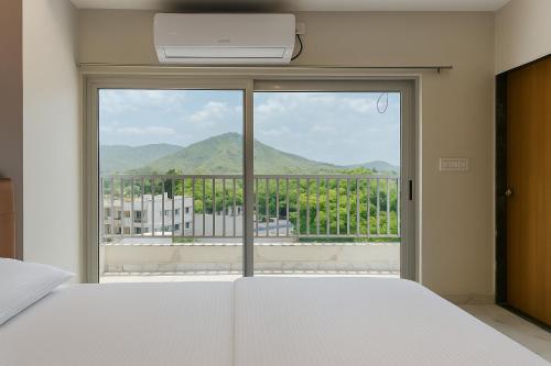 a bedroom with a bed and a window with a view at Hotel KARDHAR INN in Ambaji