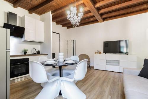 a living room with a table and chairs and a kitchen at Porta Torre - Guest Suite in Como