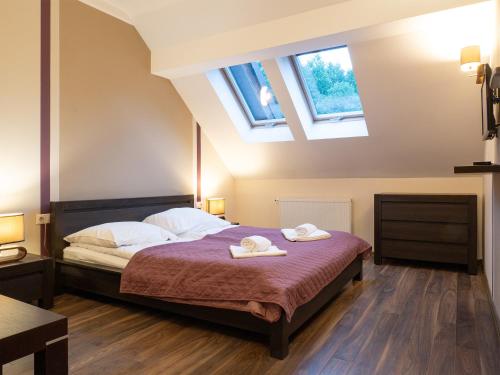 a bedroom with a bed with two towels on it at Dolina Leśnicy SKI & SPA Resort in Brenna
