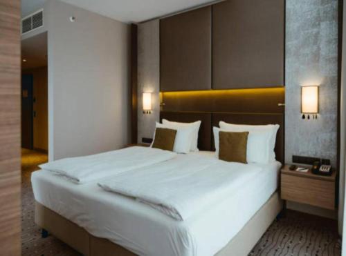 a large white bed in a hotel room at Hotel Empire Suites Near Delhi IGI Airport in New Delhi